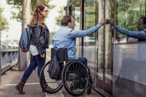 Wheelchair using young man and his girlfriend travelling around a modern city